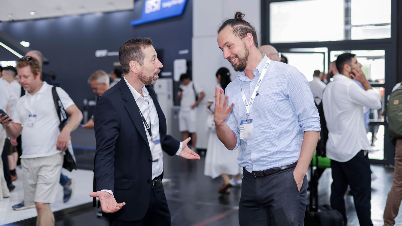 Sergey Syrvachev in conversation with a colleague on the floor of an energy storage trade show